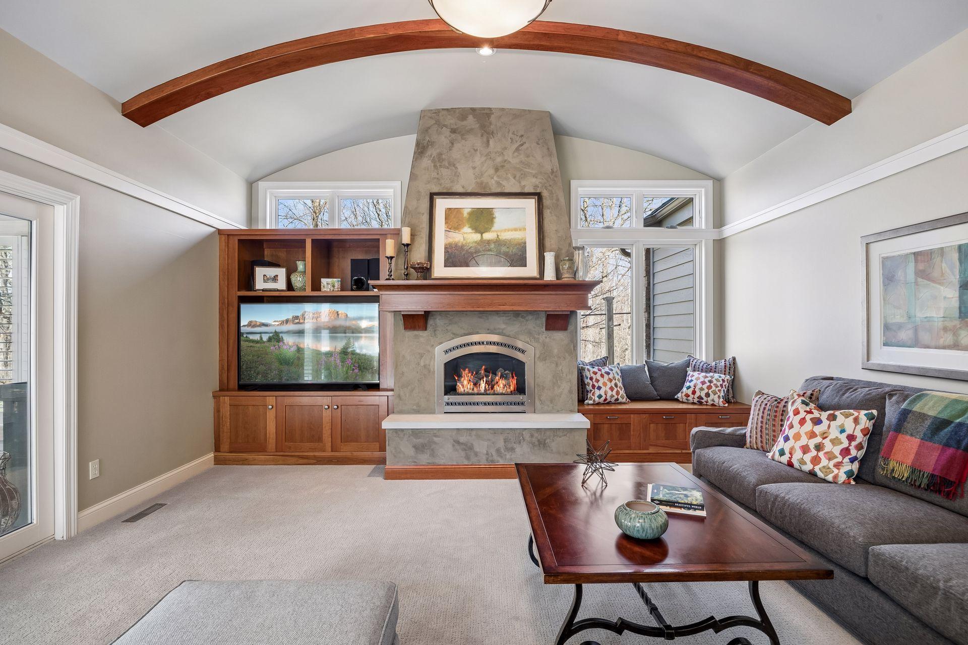 Perfect living space on the main level with a gas fireplace and built-in cabinetry for storage and decor. All TVS stay with the house!
