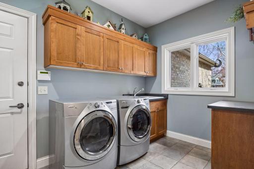 Laundry room with washer, dryer and sink. Nice counter space to have as well.