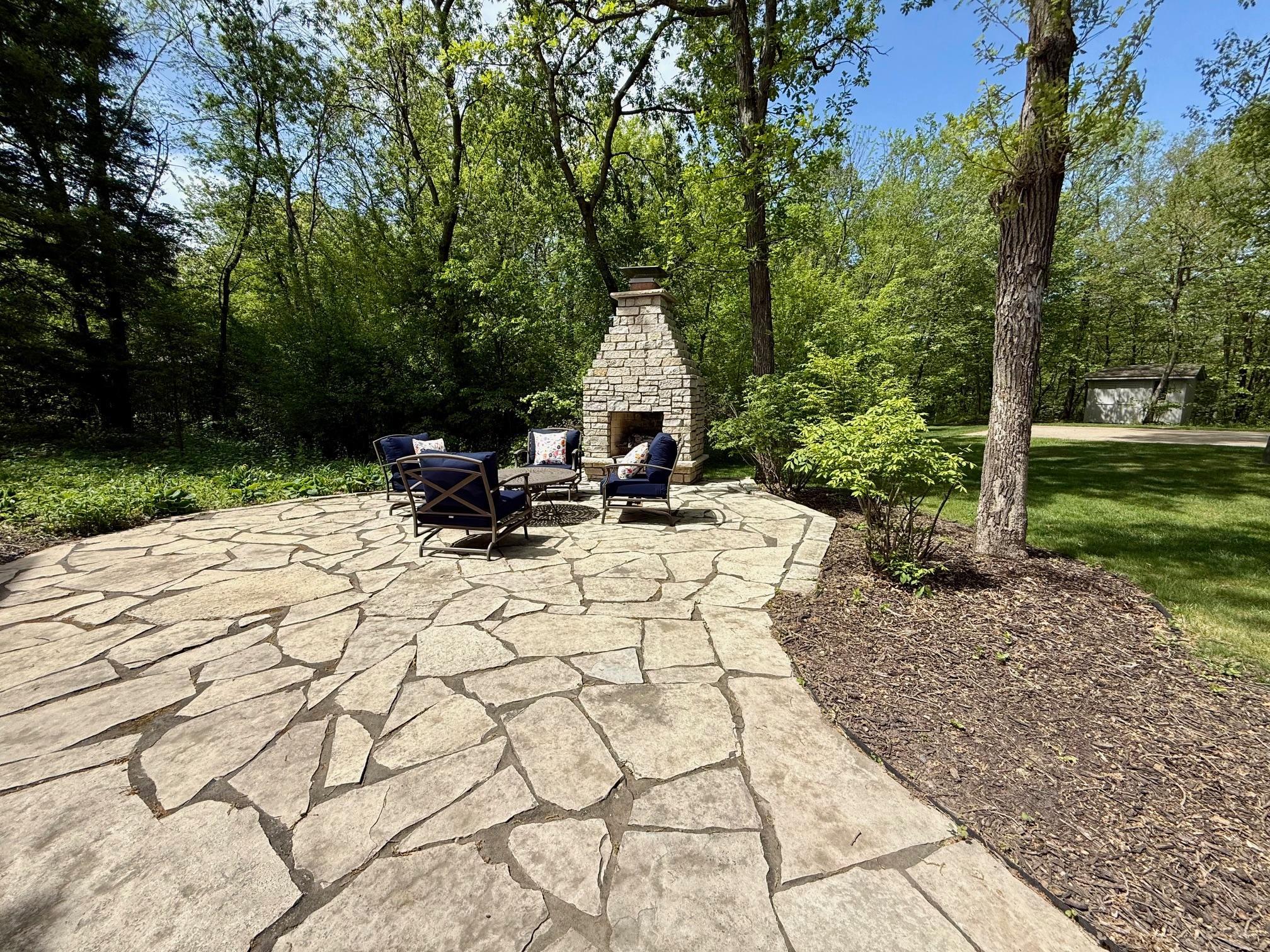 Patio in the backyard with fireplace that has a great space for seating options. Sit and enjoy the views!