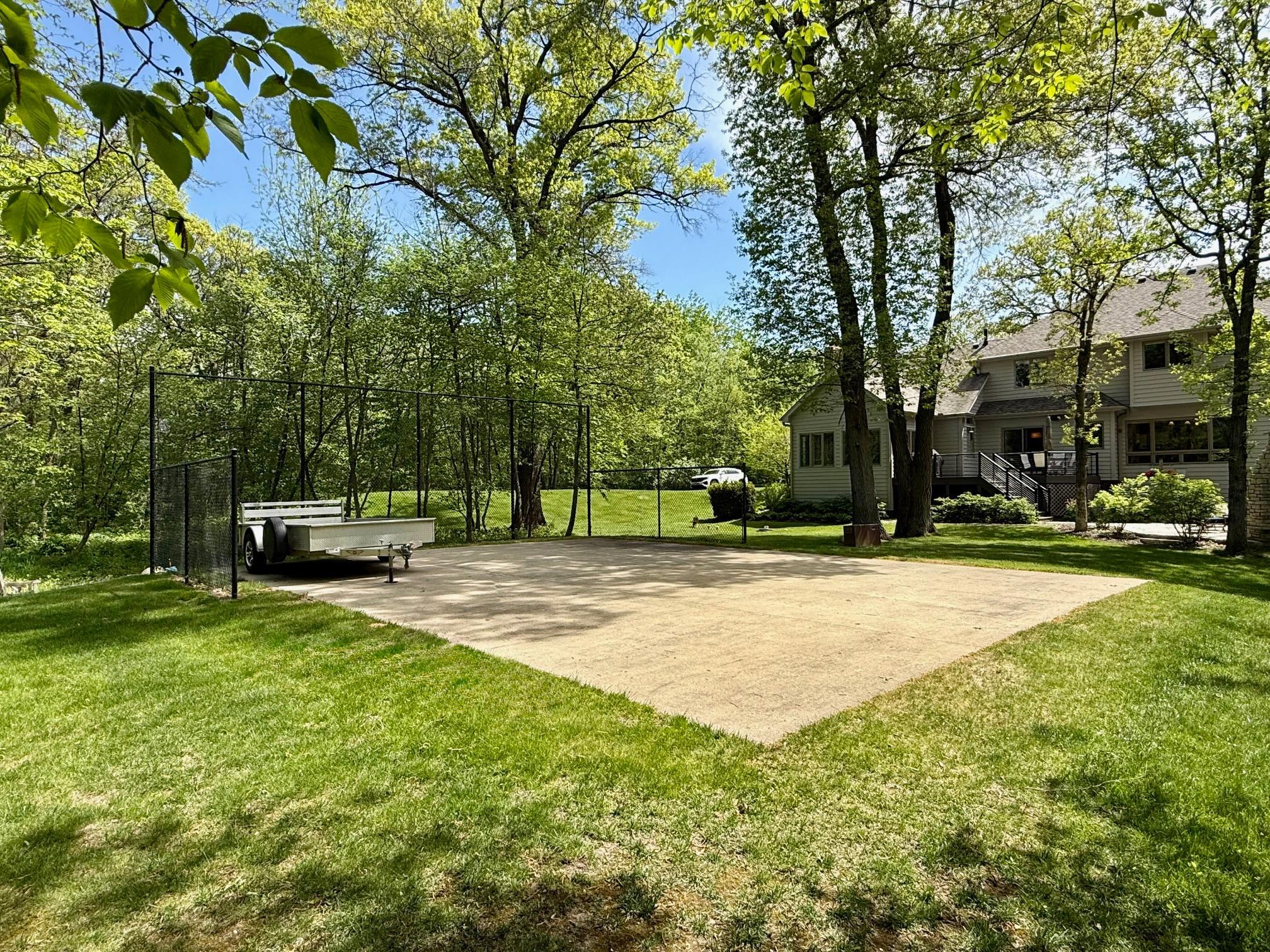 Backyard view where you can see the sport court that can also be transformed to another garage because of the concrete slab.