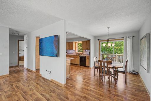 Open concept on the main level with a pano view from the living room looking towards the dining room, deck, and kitchen