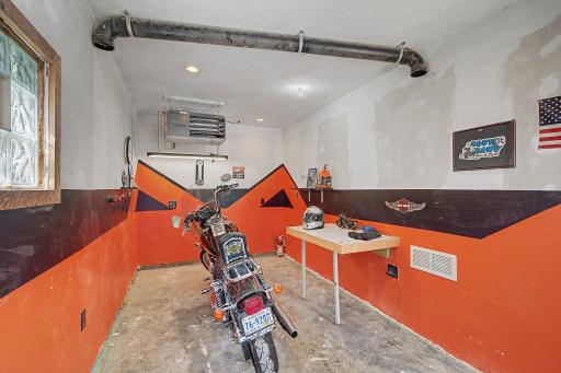 The 2.5 car super-sized garage has a sheetrocked and heated workshop. It's the perfect mancave to wrench andd tinker in~even when it's 20 below outside, you'll be wrenching on your sleds and cycles in a t-shirt. How cool is this custom designed paint