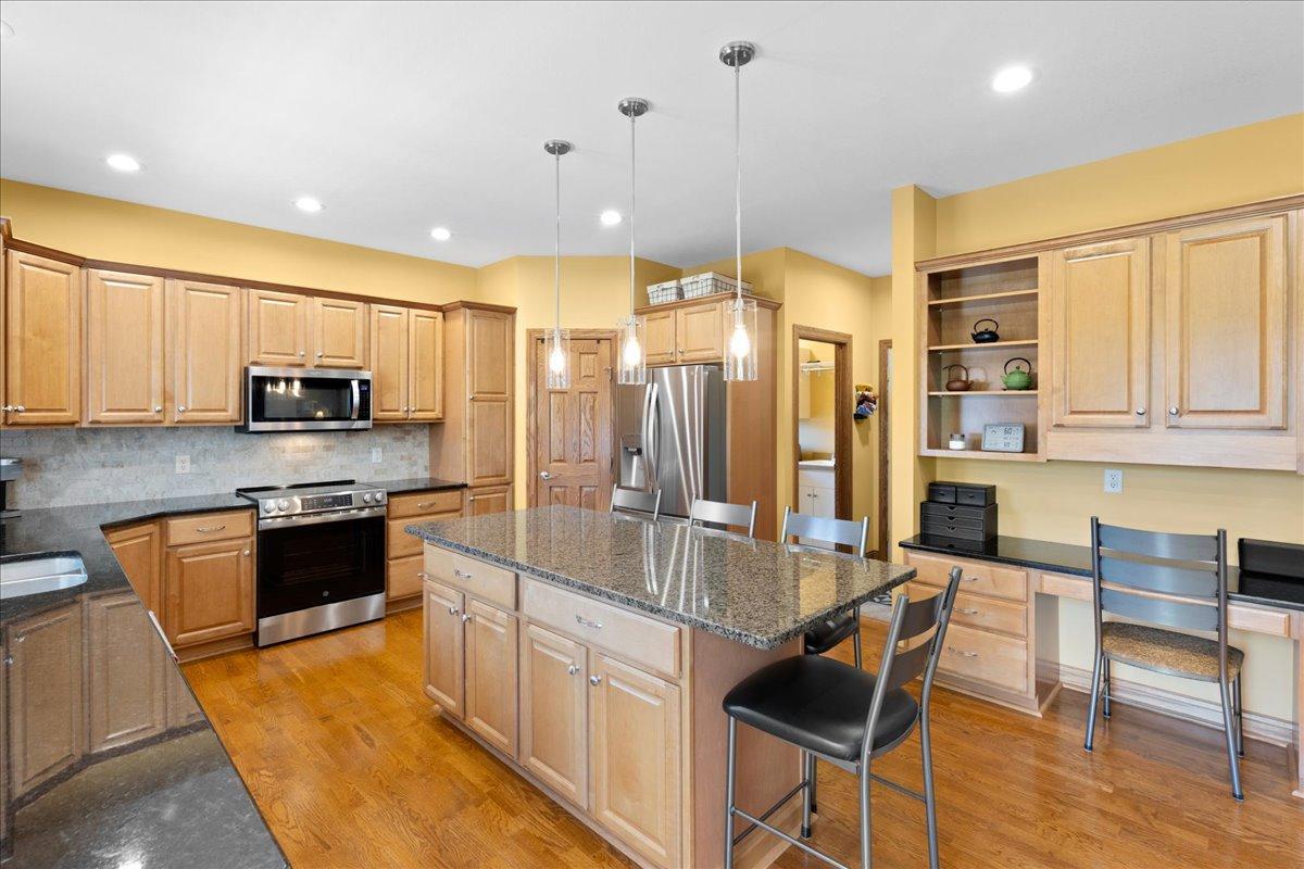 Gourmet Kitchen with granite on the Center Island and the perimeters, an abundance of cabinetry, stainless steel appliances, gleaming hardwood floors