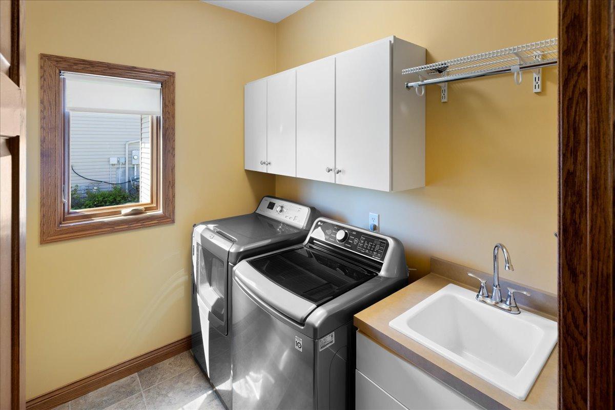 Main floor Laundry Room with built-in uppers and lowers, utility sink, hanging rod