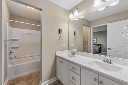 Full walk-though bathroom with double sinks.
