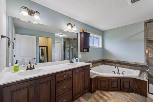 Primary bathroom features double sinks, soaking tub, standing shower, and walk in closet.