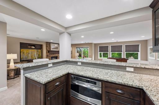 Bar area features full refrigerator, microwave, sink, and granite countertops