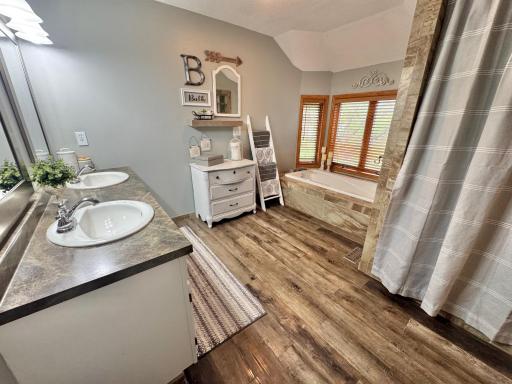 Primary bath includes double sink, spa tub & tiled shower.