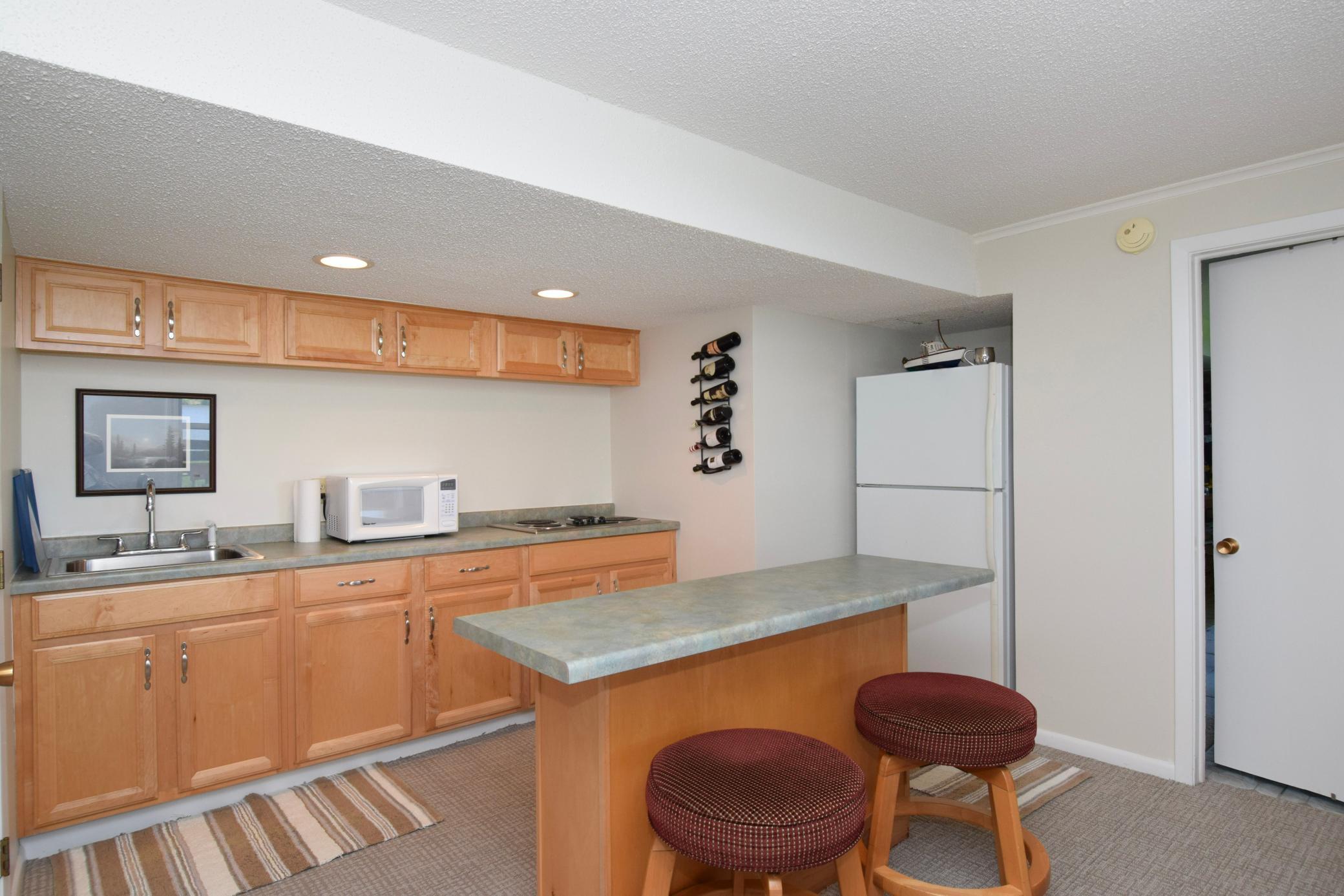 Lower level extra kitchen. Cook top, microwave and refrigerator. Another space for entertaining.