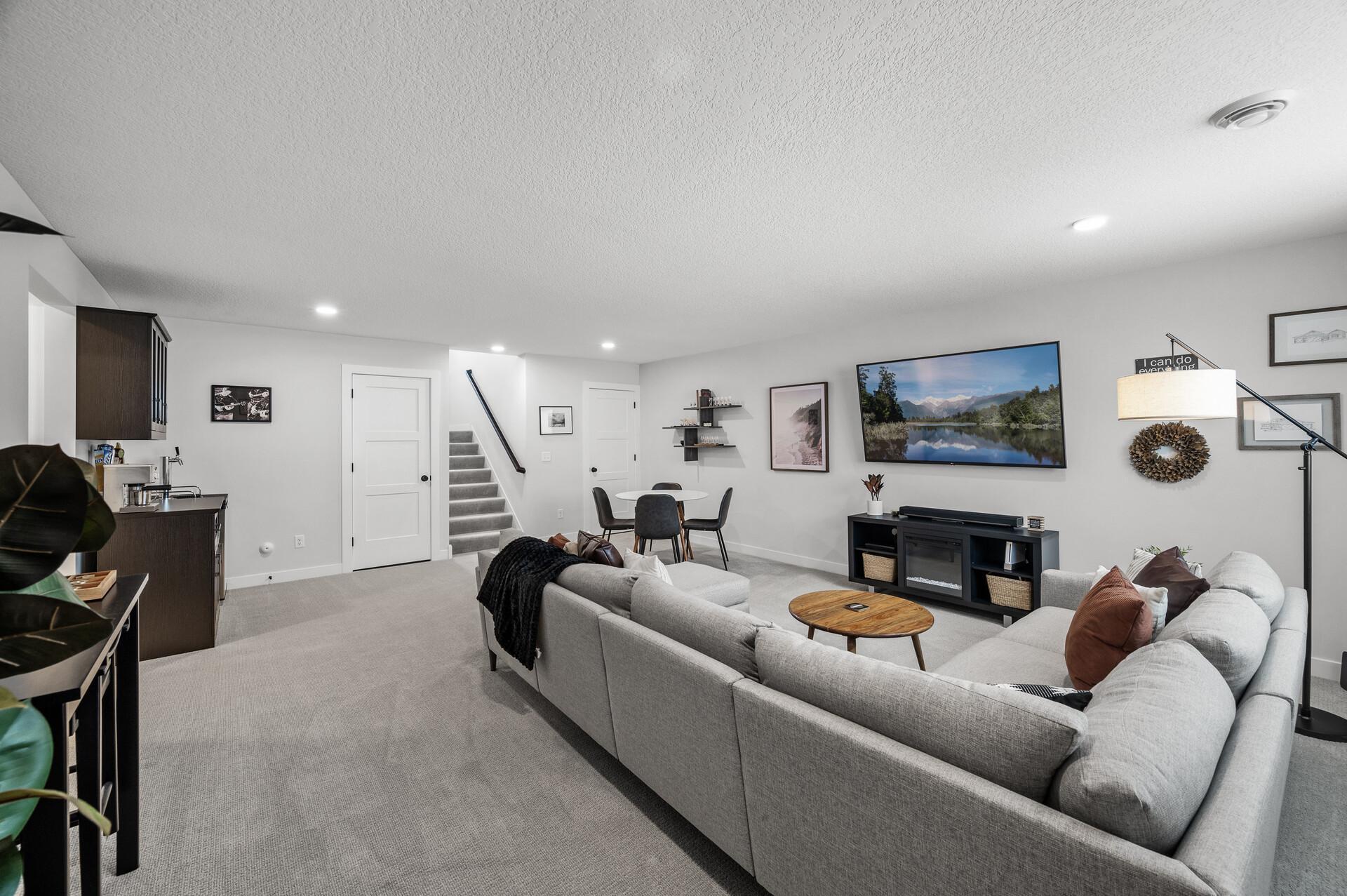 Head down to the lower level, and you will find your family room! Another entertaining spot! Behind those two doors are storage options.