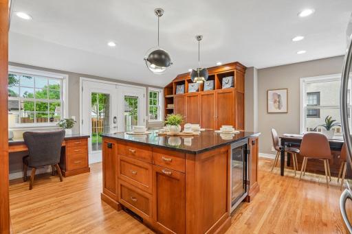 The rich, substantial island serves as the heart of the kitchen, featuring generous storage, casual seating, an integrated warming element, and a convenient Sub-Zero wine fridge.