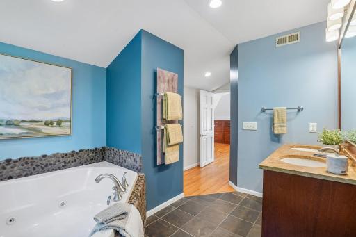 An alternate view highlights the soothing whirlpool tub and the added comfort of a luxury heated towel rack