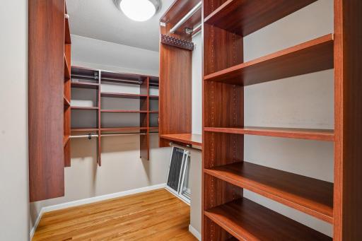 The private walk-in closet boasts matching wood shelving that coordinates beautifully with the suite's built-in drawer storage