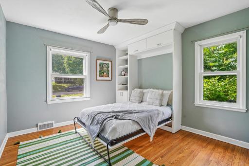 Thoughtful space-saving design shines in a main-level bedroom equipped with a built-in Murphy bed, delivering seamless flexibility as a dual-purpose bedroom, office, play space or craft/hobby area