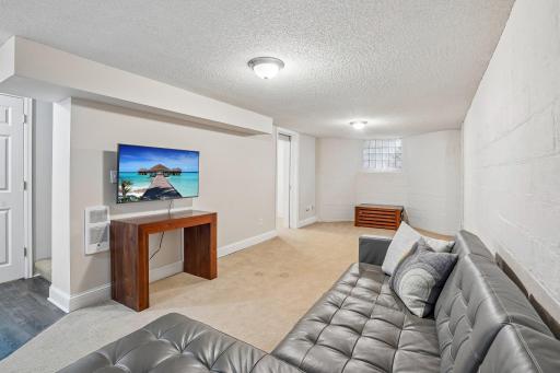 The lower level features a comfortable rec room, perfect for movie marathons, family game nights, and casual relaxation