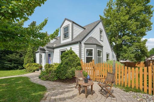 The charming front patio, complete with a bistro set, offers the perfect setting to enjoy morning coffee, evening drinks, and connection with neighbors