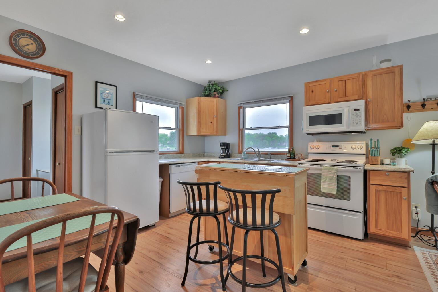 Bright and sunny kitchen with new sink with view of the lake, new flooring throughout living area.