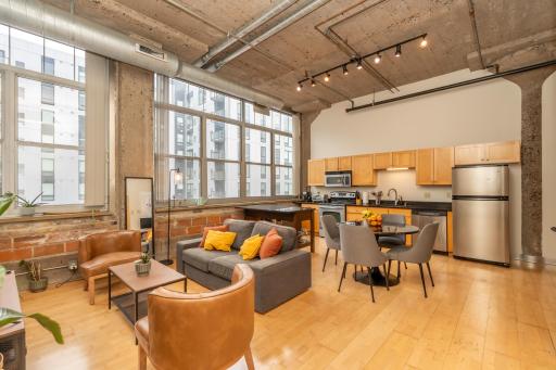 Massive wall-to-wall windows flood the open-concept living space with natural light and showcase stunning city views