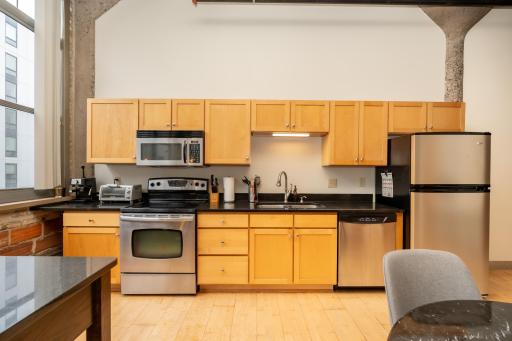 Kitchen features granite countertops, stainless steel appliances, ample cabinetry, and a large movable island for added prep and serving space