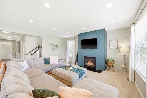 Inviting living room with cozy gas fireplace, custom accent wall, and open-concept layout designed for relaxing evenings and effortless entertaining.