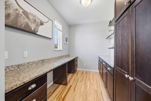 Functional butlerâs pantry with extensive countertop workspace, abundant cabinetry, and built-in desk areaâperfect for coffee bar setup, meal prep, or additional storage.
