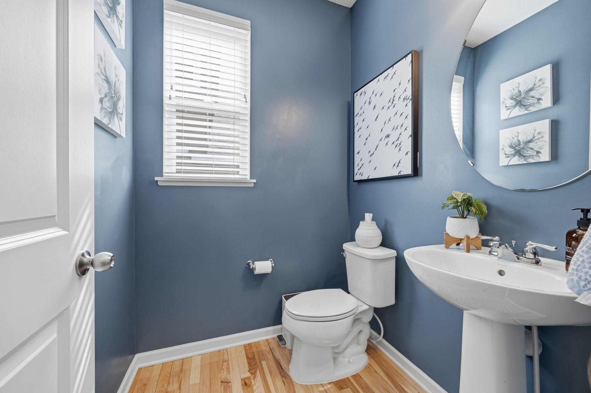 Stylish main-level powder room featuring designer paint tones, natural light, and clean modern finishes for guests and everyday convenience.