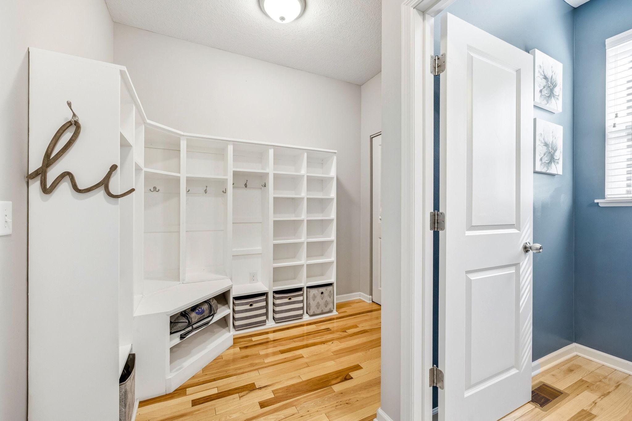 Functional mudroom with custom built-in lockers, cubbies, and bench seating offers exceptional everyday organization and convenient access off the garage entry.