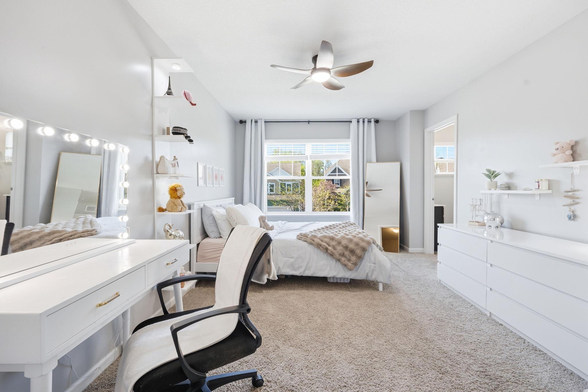 Spacious secondary bedroom with large picture window, plush carpeting, and flexible layout perfect for a bedroom, study space, or teen retreat.