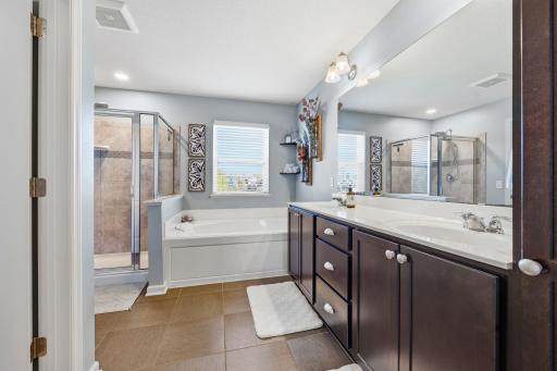Luxurious primary ensuite featuring dual-sink vanity, soaking tub, separate walk-in shower, and spacious layout designed for comfort and relaxation.