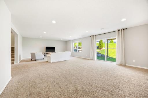 Expansive finished walkout lower level with oversized family room, abundant natural light, and flexible space ideal for entertaining, recreation, fitness, or future game areas.
