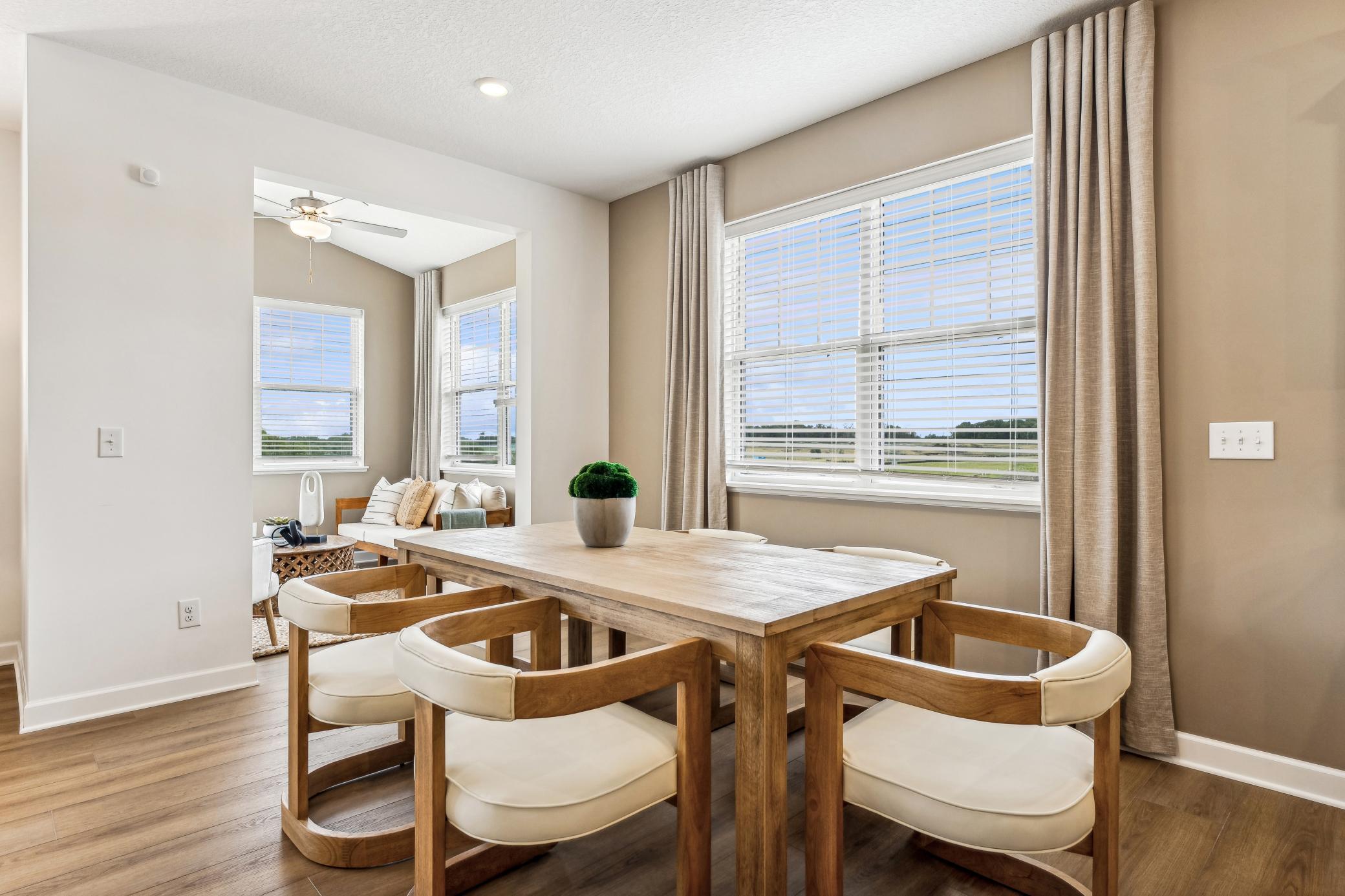 (Photo of a decorated model, actual homes finishes will vary) Soaked in natural sunlight, the homes eat-in dining room has ample space for a dining table located in the heart of the home.