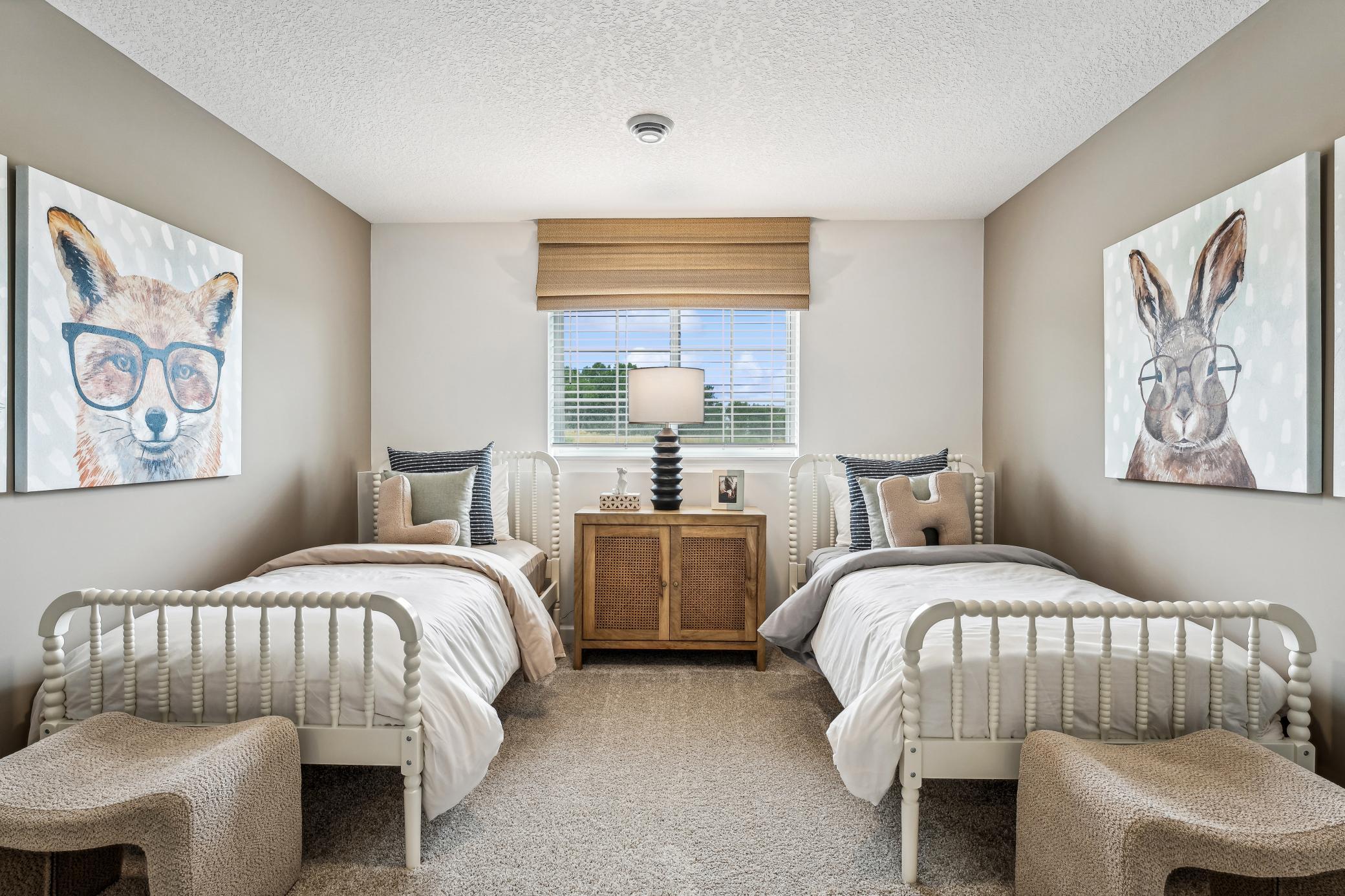 (Photo of a decorated model, actual homes finishes will vary) Lower-level bedroom.