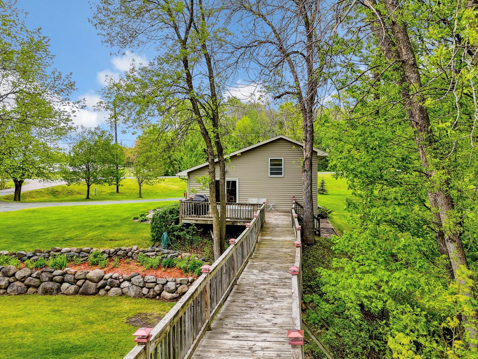 Walk way over natural creek from home to pole building