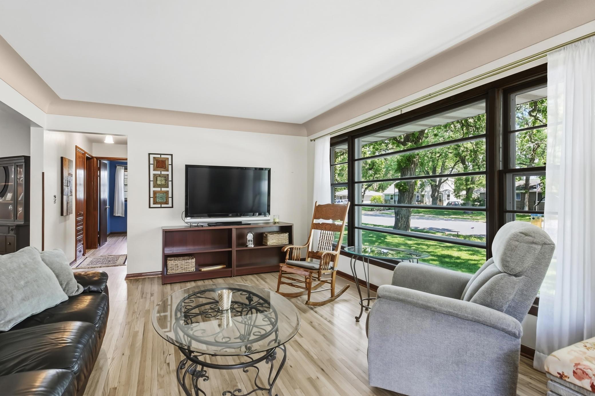 Spacious living room featuring an abundance of sunshine, hardwood flooring thorughout..jpg
