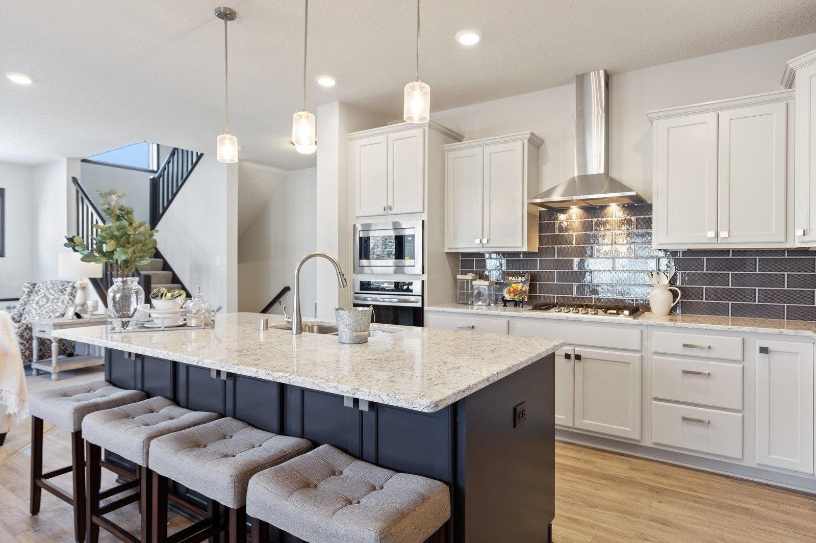 gourmet kitchen with wall ovens and wood