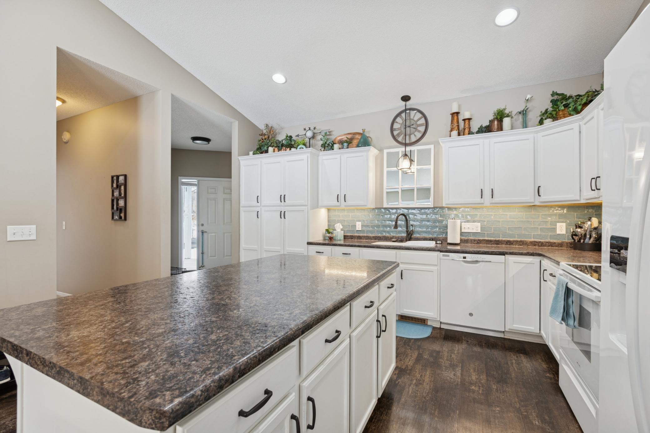The kitchen has a large center island. There is luxury plank flooring in the kitchen, hallway and main level bathrooms. The under cabinet lighting is an added bonus!