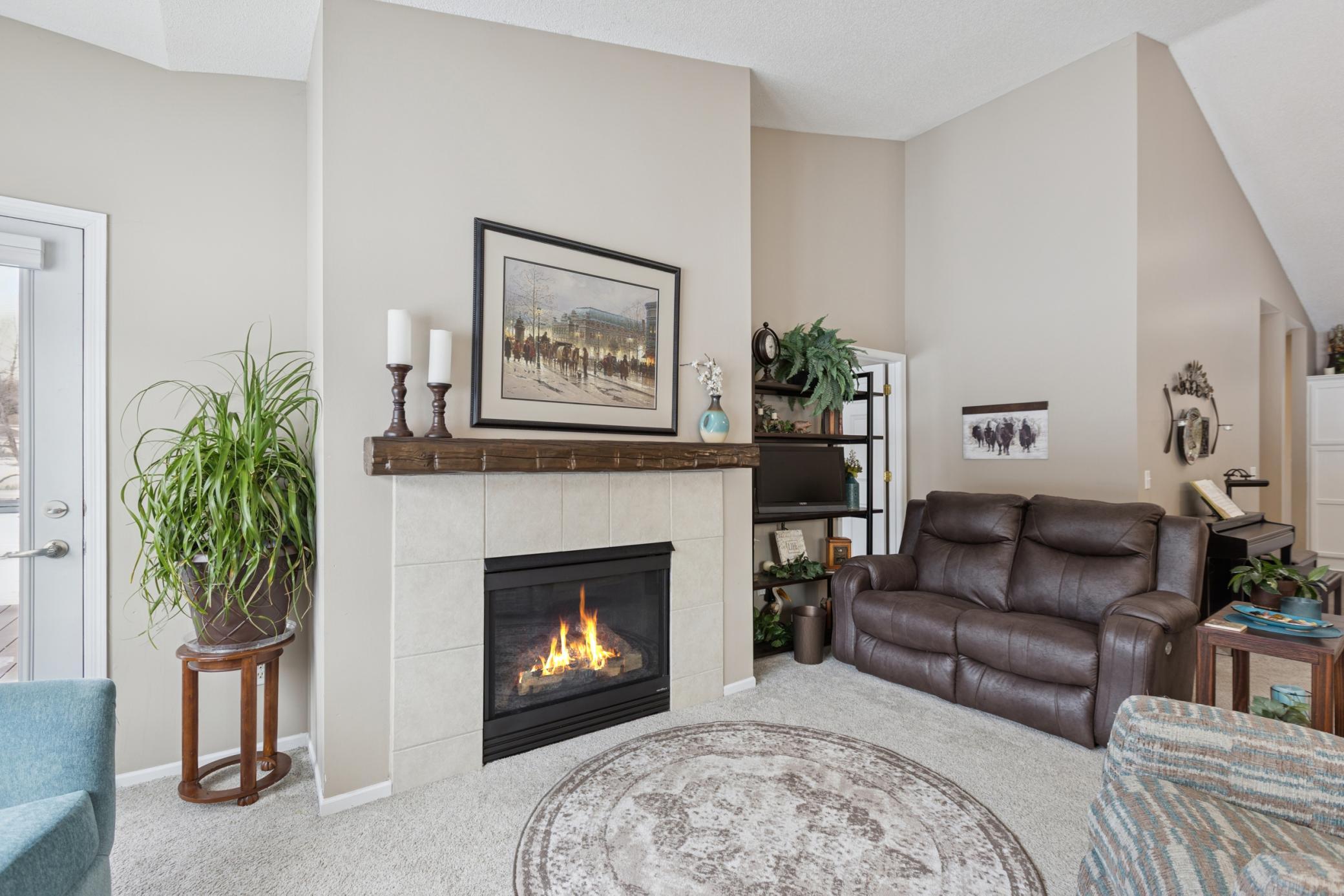 The cozy living room has a gas fireplace with tile surround.