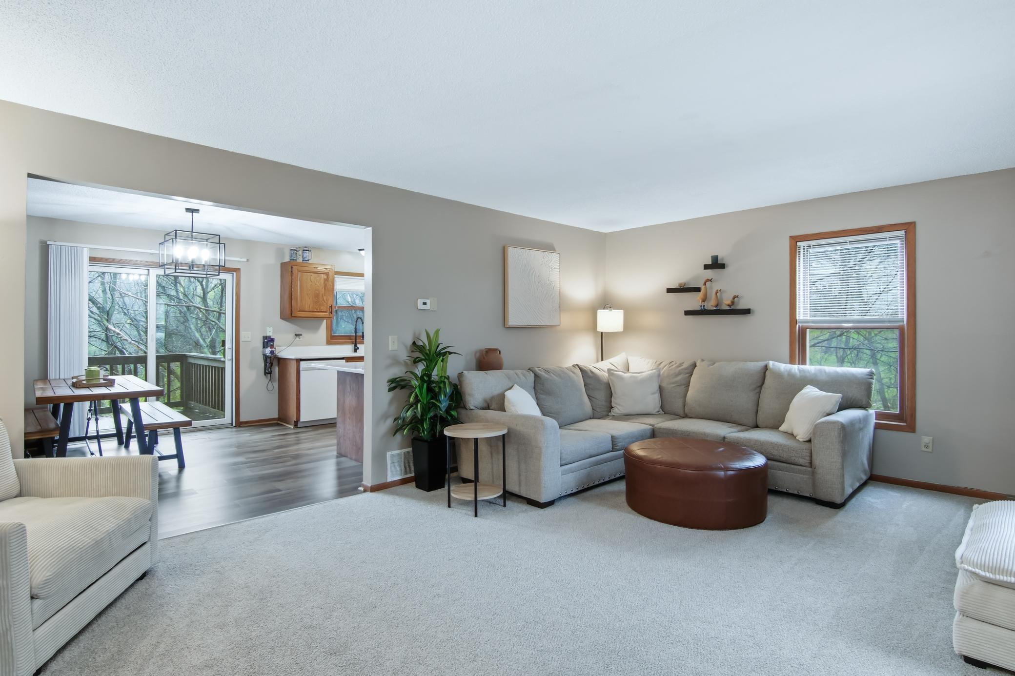 A roomy living room with carpet that is just one year old.