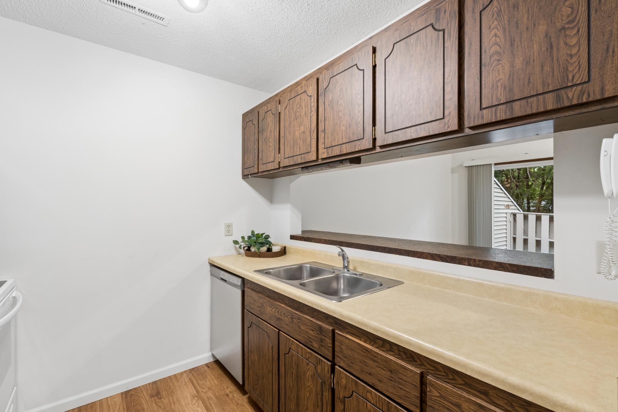 The galley-style kitchen features an open sightline to the living room, creating a connected and functional layout.