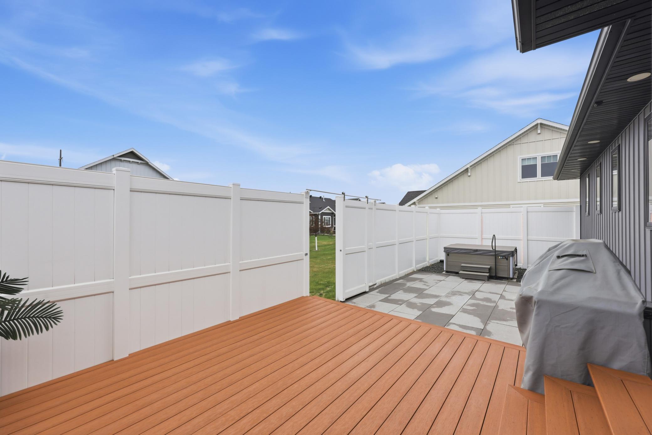 fenced patio area with gate leading to remaining yard space