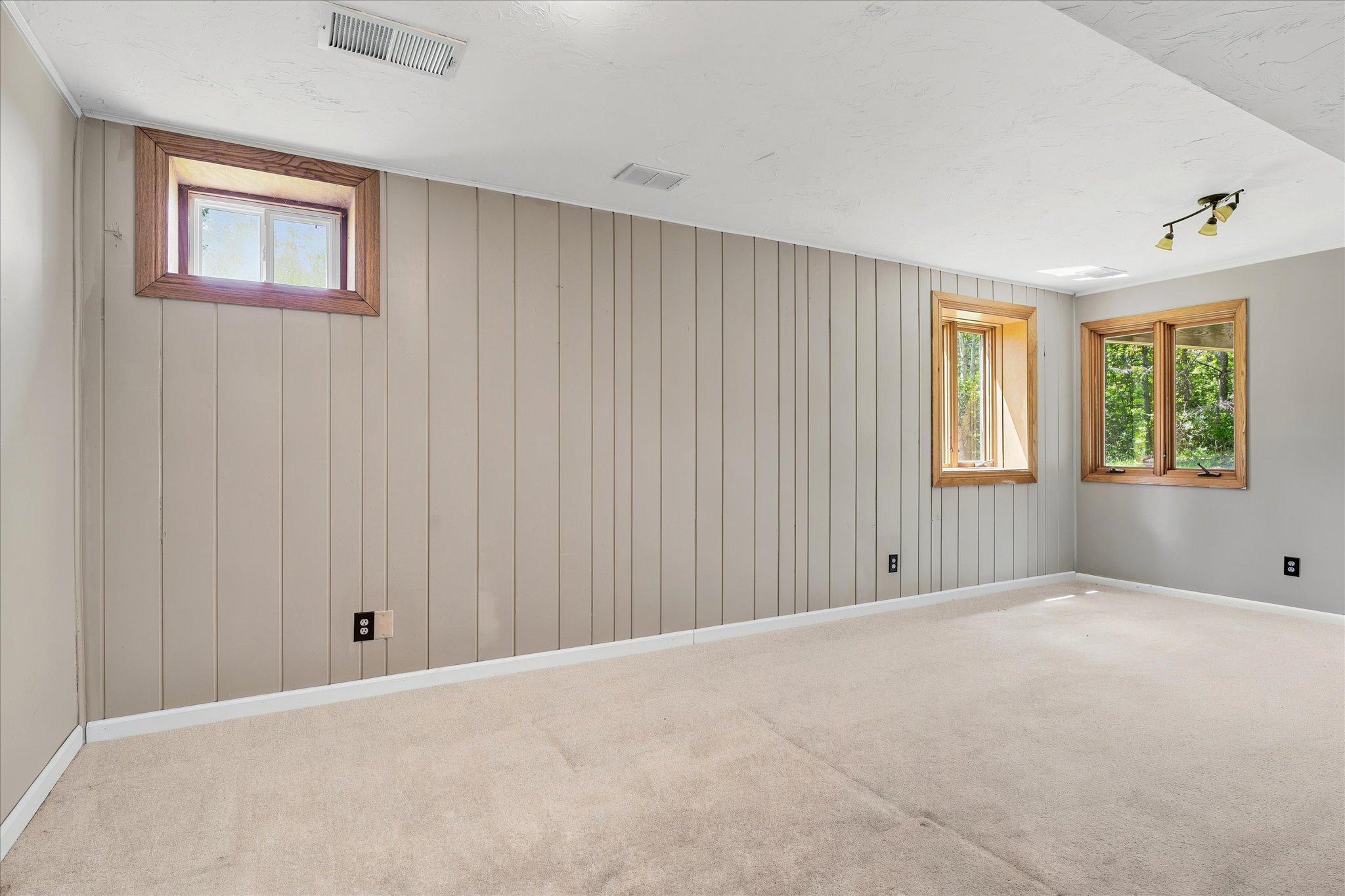 Lower family room. *Keep home as primary, or Approved for ADU/guest house - modifications to complete with your builder. Survey available with new placement for your dream home!