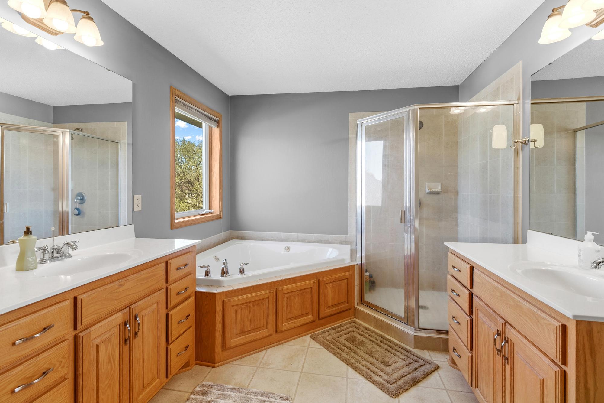 The Primary Bath offers a spa-like experience. Soak in the jetted corner tub. Separate walk-in tiled shower. Dual sinks and separate countertops. There's an abundance of cabinet and counter space.