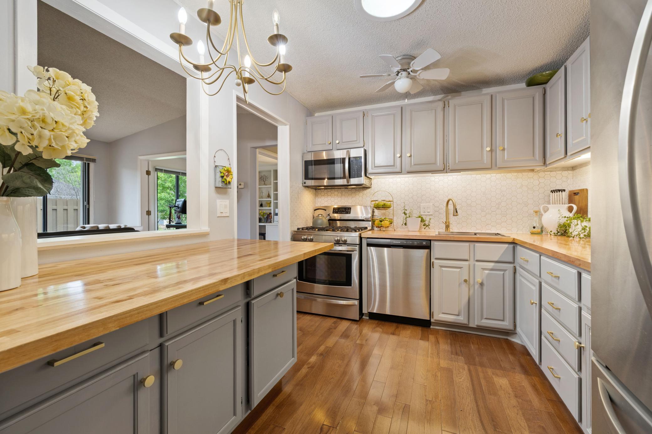 Hardwood floors, butcher block countertops in kitchen. Mosaic tile backsplash.