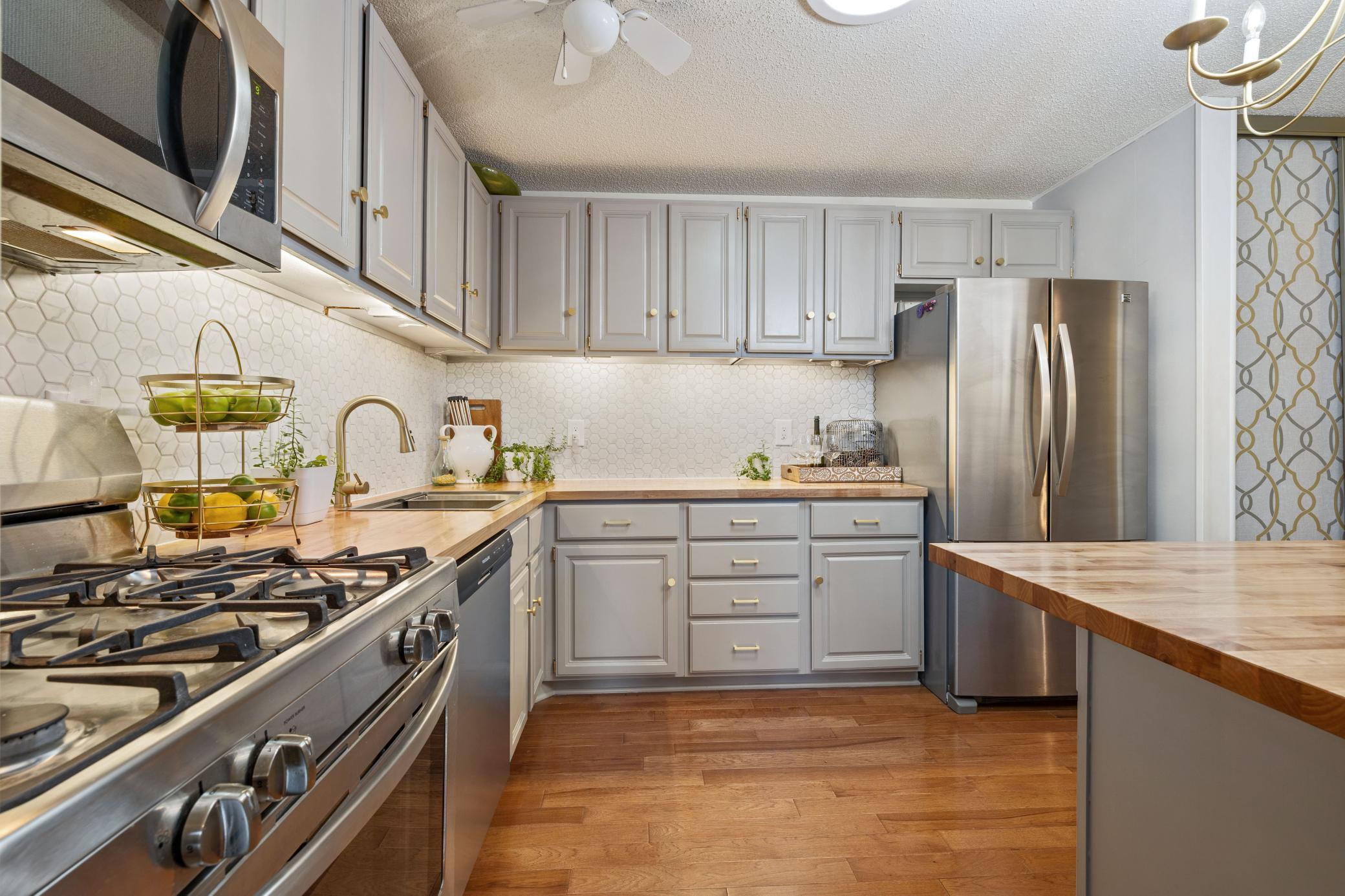 Stainless steel appliances, under cabinet lighting, hardwood floors.