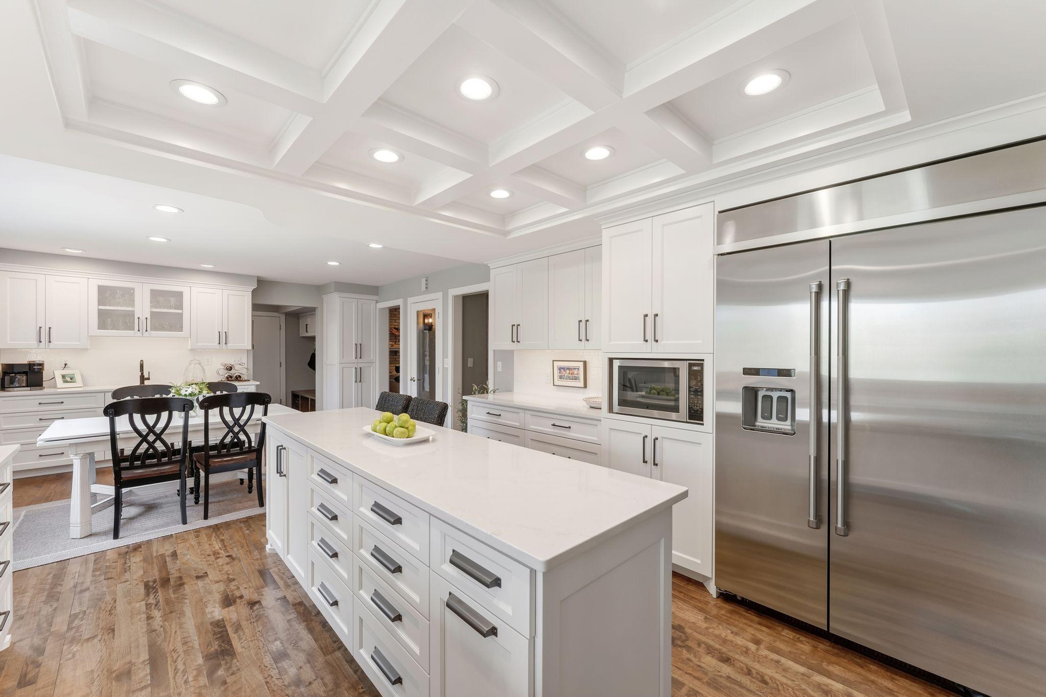 Beamed, coffered ceilings with recessed lighting adds style for days!