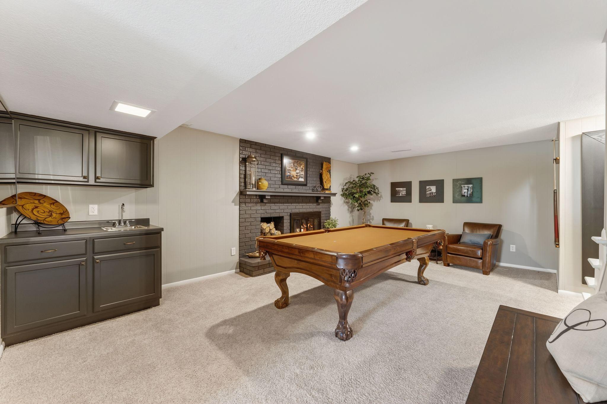This room has a moody vibe with a wet bar and a pool table.
