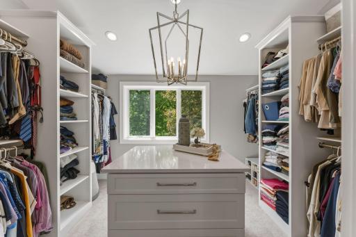 There are walk in closets...and then this happens!! An island with a quartz counter top, drawer for days, custom closet shelving, floor to ceiling storage and a statement chandelier tying it all together!