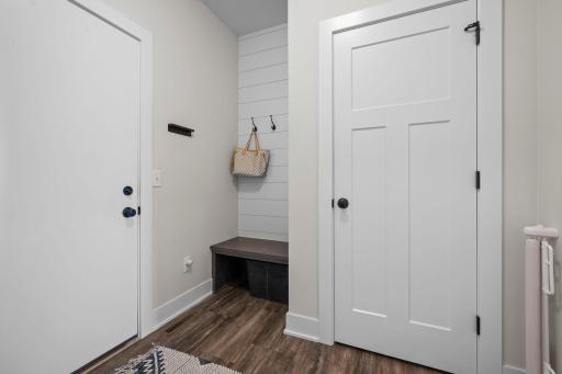 The mudroom features a built-in bench with hooks and an additional closet for extra storage and organization