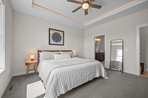 Accented by elegant in-ceiling tray lighting and a ceiling fan for added comfort and style