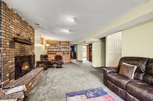 âThe lower-level family room offers a cozy wood-burning fireplace, perfect for Minnesota evenings.â Built in Bookcase and desk made of natural wood, stay with the home
